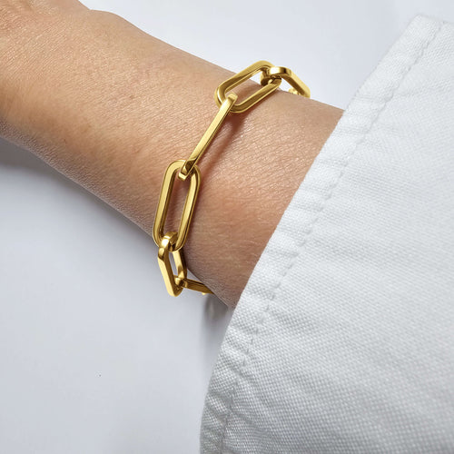 RALLUNA Sculptural Paperclip Chain Bracelet in gold-tone 316 stainless steel on a model's wrist against a clean white background